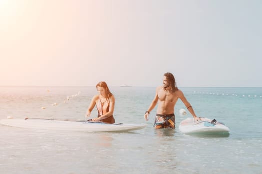 Woman man sea sup. Close up portrait of beautiful young caucasian woman with black hair and freckles looking at camera and smiling. Cute woman portrait in a pink bikini posing on sup board in the sea