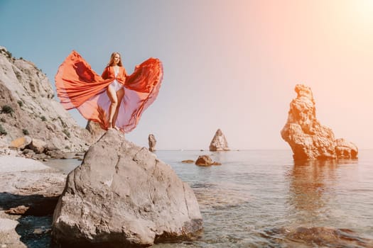 Woman travel sea. Happy tourist taking picture outdoors for memories. Woman traveler looks at the edge of the cliff on the sea bay of mountains, sharing travel adventure journey.