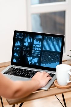 Hand Resting On Laptop Top Of Table Beside Cup Working From Home.