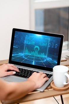 Both Hands Typing On Laptop Next To Cup And Plant Working From Home.