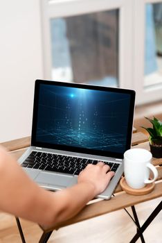 Hand Busy Typing On Laptop Beside Coffe Mug And Plant Working From Home.