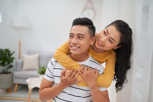 Asian couple piggyback ride indoor