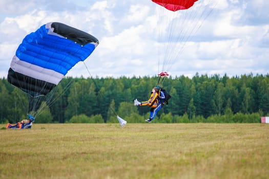 Landing skydivers-athletes with a parachute on the ground. High quality photo. Kirzhach Russia July 22, 2023