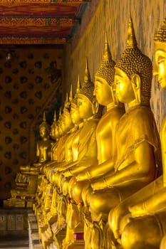 Golden Buddha statue on the pedestal with old walls