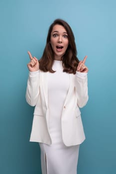 smiling young brunette with long hair lady in white dress has a cool idea and wants to tell about it.