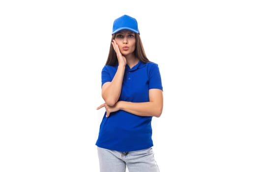 well-groomed young brunette woman promoter in a blue t-shirt and cap on a white background with copy space.