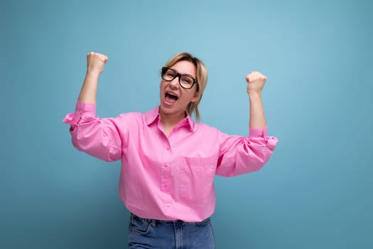 young confident smart european blond office worker woman wearing pink shirt and jeans over isolated studio background with copy space.