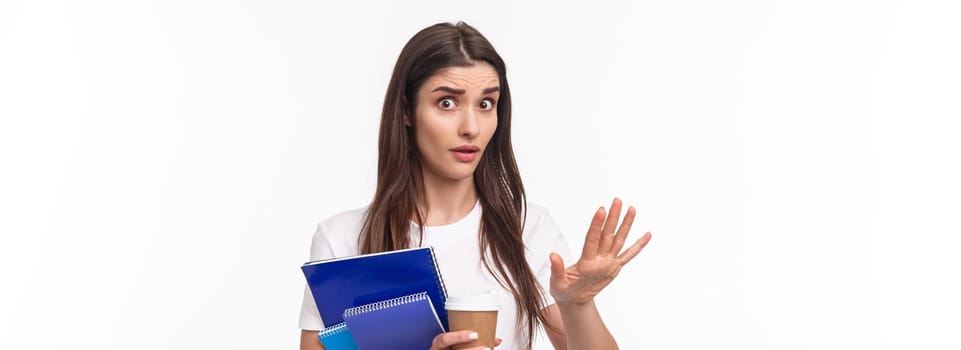 Education, university and studying concept. Wow come down, slow for minute. Close-up portrait of freaked-out shocked young female student saying stop, chill gesture, look concerned hold notebook.