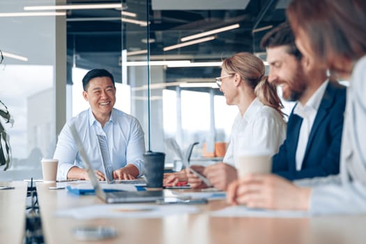 Workteam of young asian businessman working and communicating together in an modern office.