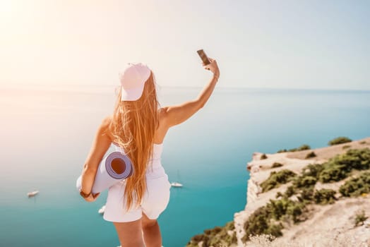 Young woman with black hair, fitness instructor in pink sports leggings and tops, doing pilates on yoga mat with magic pilates ring by the sea on the beach. Female fitness daily yoga concept