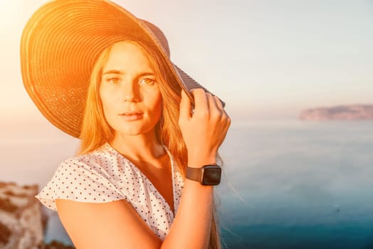 Portrait of happy young woman wearing summer black hat with large brim at beach on sunset. Closeup face of attractive girl with black straw hat. Happy young woman smiling and looking at camera at sea