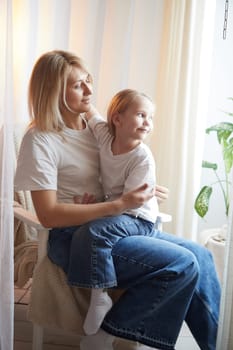 Happy loving family with mother and daughter in living room. Woman mom and small child girl playing and having convercation inside of home