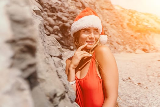 Woman travel sea. Young Happy woman in a long red dress posing on a beach near the sea on background of volcanic rocks, like in Iceland, sharing travel adventure journey