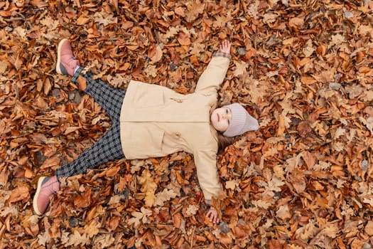 girl lies in fallen leaves