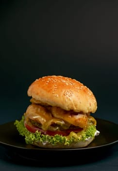 Homemade tasty double burger with beef, salad, bacon, tomatoes and cheese on wooden background. Rustic style.