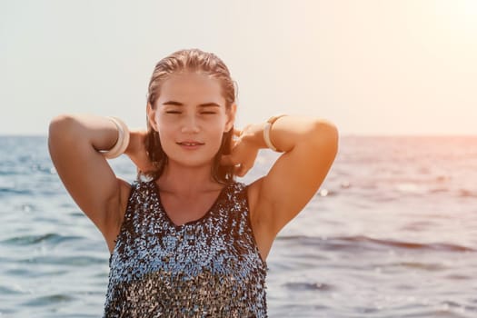 Woman travel sea. Young Happy woman in a long red dress posing on a beach near the sea on background of volcanic rocks, like in Iceland, sharing travel adventure journey