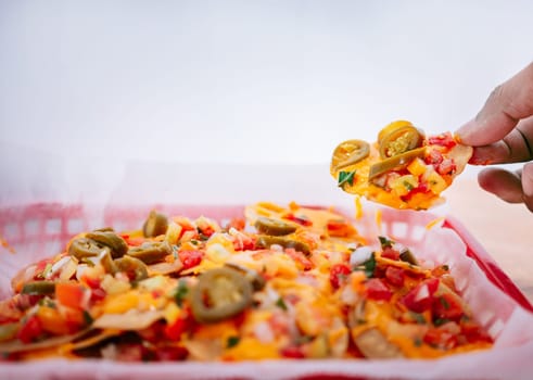 Hand of people taking nachos on isolated background. Hand taking nachos from a tray