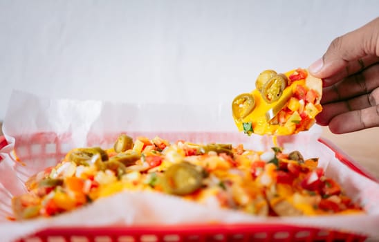 Hand taking nachos from a tray. Hand of people taking nachos on isolated background
