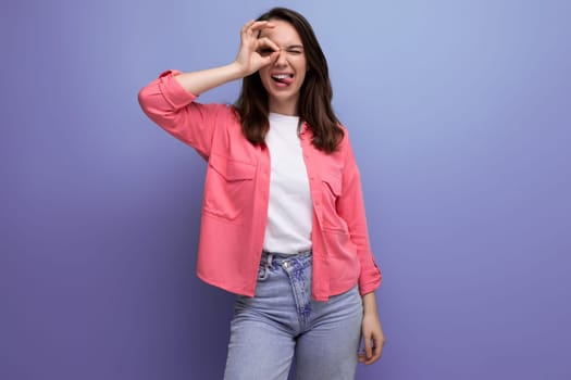 caucasian brunette young woman with shoulder-length hair in a pink shirt and jeans.