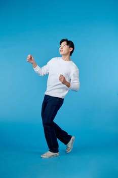 full body image of asian man posing on blue background