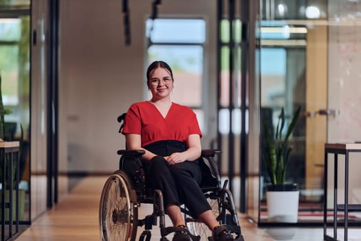 A modern young businesswoman in a wheelchair is surrounded by an inclusive workspace with glass-walled offices, embodying determination and innovation in the business world.