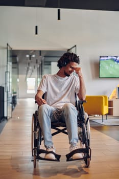A sad businessman in a wheelchair occupies a hallway within a modern startup coworking center, embodying inclusivity and determination in the business environment.