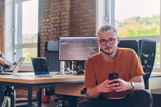 A modern businessman takes a relaxing break from work, using his smartphone to unwind and recharge during his pause.