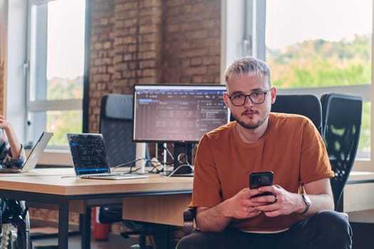 A modern businessman takes a relaxing break from work, using his smartphone to unwind and recharge during his pause.