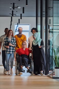 A diverse group of young business people walking a corridor in the glass-enclosed office of a modern startup, including a person in a wheelchair and a woman wearing a hijab, showing a dynamic mix of innovation and unity