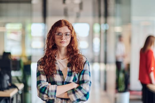 A portrait of a young businesswoman with modern orange hair captures her poised presence in a hallway of a contemporary startup coworking center, embodying individuality and professional confidence