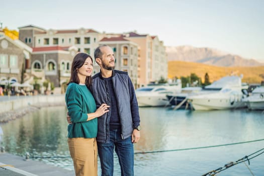 Couple in love tourists enjoying the views of Architecture and luxury yachts in Lustica Bay, Montenegro. Travel around Montenegro concept. Go Everywhere.