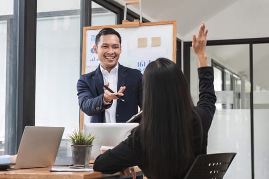 colleagues asking a question to a businessman during a presentation..