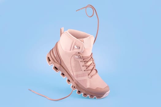 pair of woman cream hiking boots,isolate on a blue background
