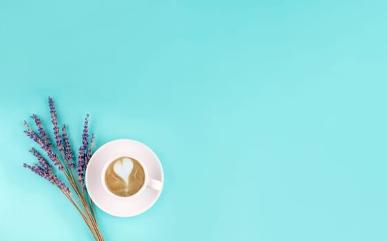 white small cup of coffee and lavander on a blue background. Space for text