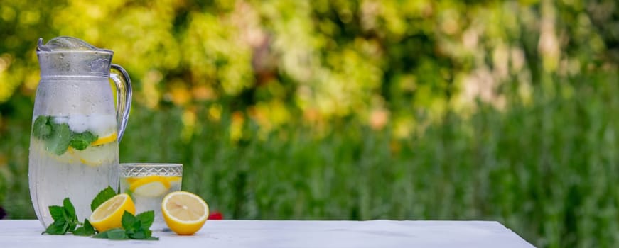 Cold lemonade with fresh lemon and crushed ice cubes. Selective focus. Outdoors