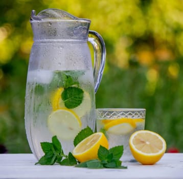 Cold lemonade with fresh lemon and crushed ice cubes. Selective focus. Outdoors