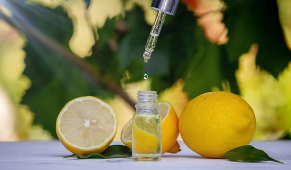 lemon essential oil and lemon fruit on a wooden white board. Selective focus