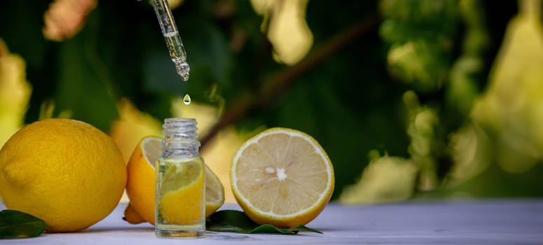 lemon essential oil and lemon fruit on a wooden white board. Selective focus