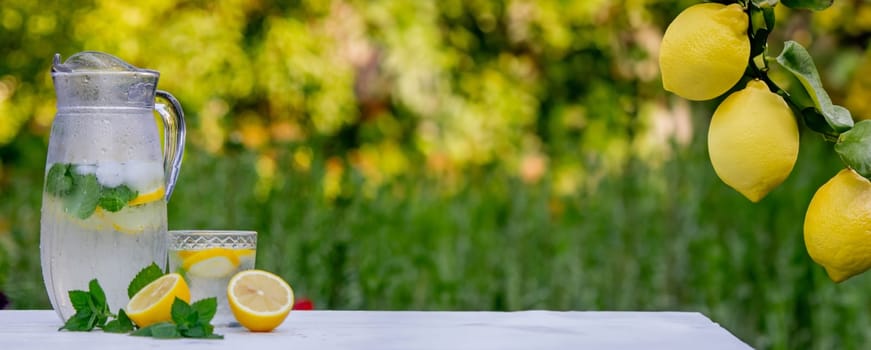 Cold lemonade with fresh lemon and crushed ice cubes. Selective focus. Outdoors