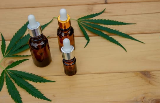 hemp essential oil on a wooden background, hemp leaves. Selective focus. Nature