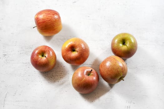 Tabletop view - red / yellow apples (kiku variety) on white working board