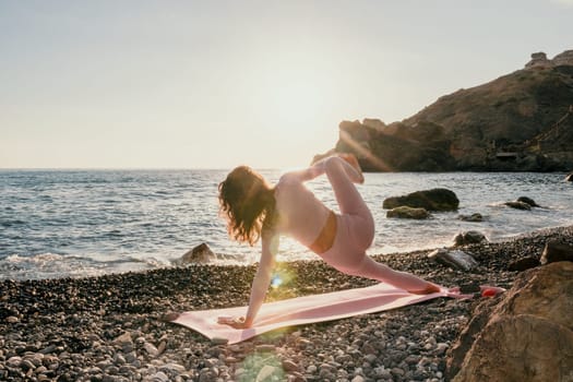 Woman sea yoga. Back view of free calm happy satisfied woman with long hair standing on top rock with yoga position against of sky by the sea. Healthy lifestyle outdoors in nature, fitness concept.