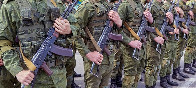 Soldiers stand in line with rifles. Soldiers shoulder to shoulder during the parade.