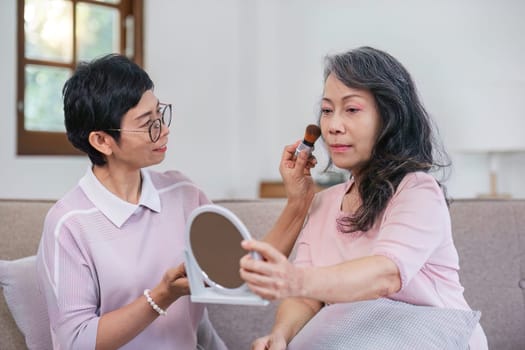 An elderly woman happily spends her free time make up with friends in the living room..