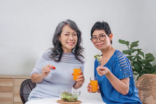 Two Asian woman enjoys talking with her friends while having a healthy food together..