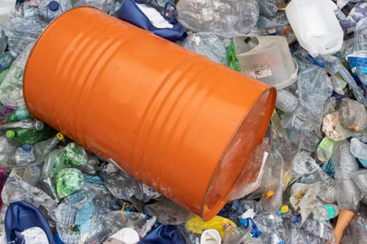 Orange barrel in a plastic garbage dump. Mid shot