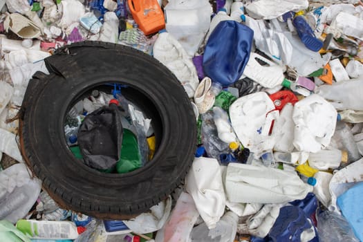 Rubber tire and plastic garbage in a landfill - a problem of environmental pollution. Mid shot