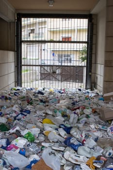 16 october 2022 Almada, Portugal: plastic garbage dump behind a mesh partition. Vertical shot