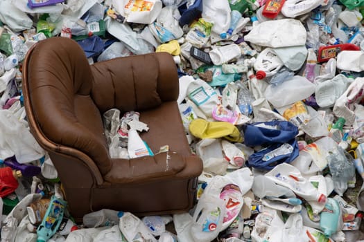 16 october 2022 Almada, Portugal: old leather chair and plastic garbage in a landfill - a problem of environmental pollution. Mid shot