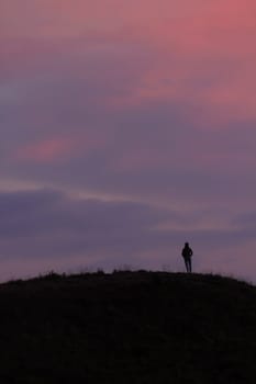 Silhouettes of people standing on the summit.